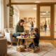 Lächelnde Therapeutin arbeitet mit einem Kind an bunten Materialien in einem hellen, salbeigrünen Therapieraum einer deutschen Grundschule.